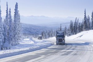 semi-truck driving on a snowy road