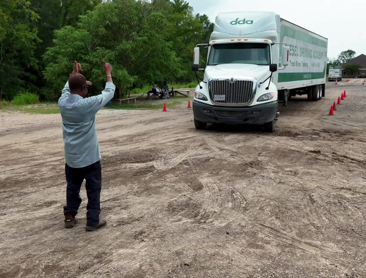 Instructor giving a thumbs up to a DDA semi truck in training yard