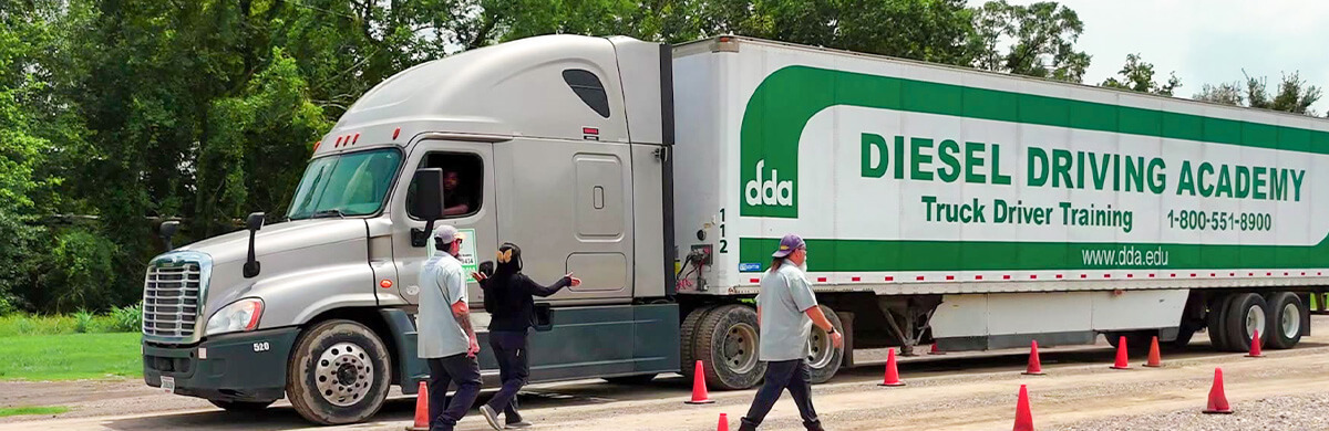 Image of DDA truck and trailer with students and instructors on yard during Hazmat Endorsement CDL training program